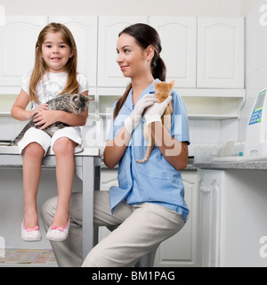 Female vet with a girl carrying cats Stock Photo