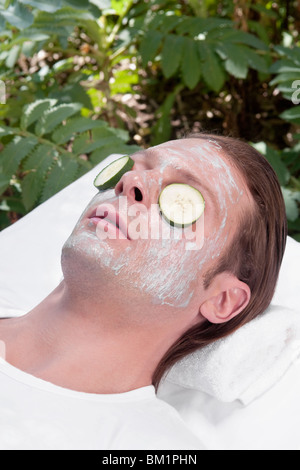 Cucumber slices on a man's eyes Stock Photo