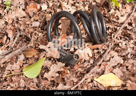 Discarded bicycle combination lock lying in dead leaves Stock Photo