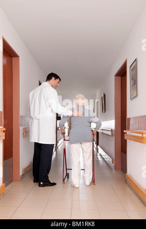 Doctor assisting a woman in walking Stock Photo