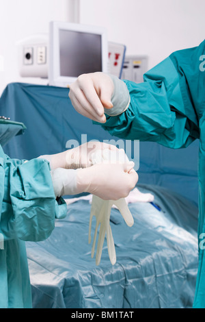 Surgeon putting on surgical gloves Stock Photo