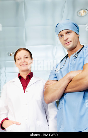 Male surgeon and a female doctor standing together and smiling Stock Photo