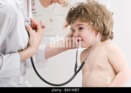Baby boy listening to a doctor's heart beat Stock Photo