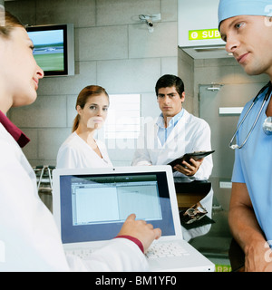 Female doctor and a surgeon discussing a medical report on a laptop Stock Photo