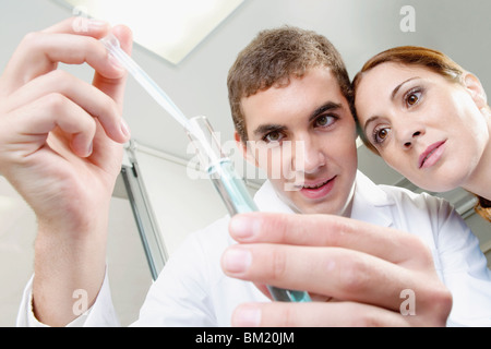 Lab technicians analyzing sample in a test tube Stock Photo