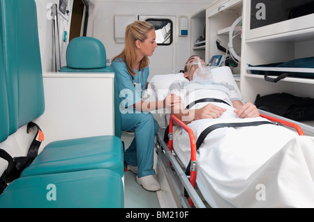 Female nurse assisting a patient in an ambulance Stock Photo