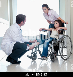 Two doctors with a patient sitting in a wheelchair Stock Photo