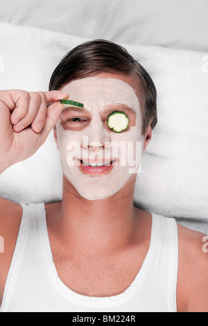 Cucumber slices on a man's eyes Stock Photo