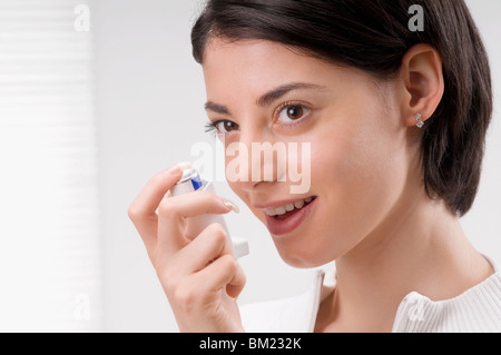 Woman using an asthma inhaler Stock Photo