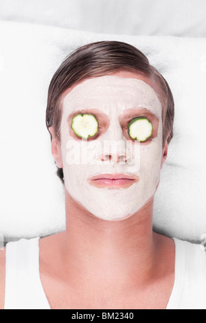 Cucumber slices on a man's eyes Stock Photo