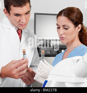 Lab technicians analyzing sample in test tubes Stock Photo