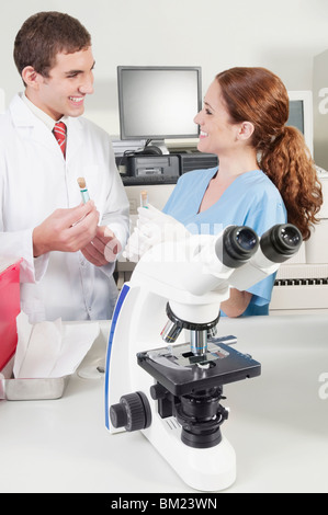 Lab technicians analyzing sample in test tubes Stock Photo