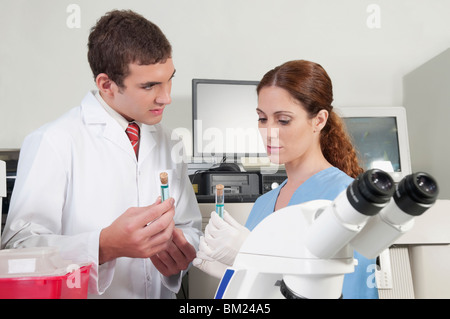 Lab technicians analyzing sample in test tubes Stock Photo