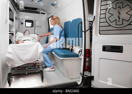 Female nurse assisting a patient in an ambulance Stock Photo
