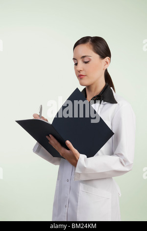 Female doctor writing in a file Stock Photo