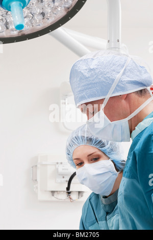 Surgeons performing a surgery in an operating room Stock Photo