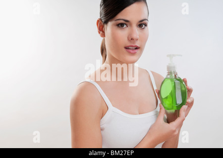 Portrait of a woman holding a bottle of liquid soap Stock Photo
