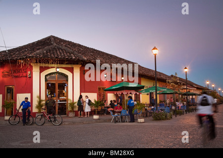 Man rideing bike past restaurant on Calle La Calzada, Granada, Nicaragua Stock Photo