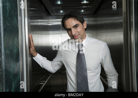 Businessman standing in front of an elevator Stock Photo