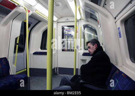 LONDON TUBE, LONELY, COMMUTER, TRAIN: London underground tube commuter commuters man alone journey tired asleep sleep sleeping on way home from work Stock Photo