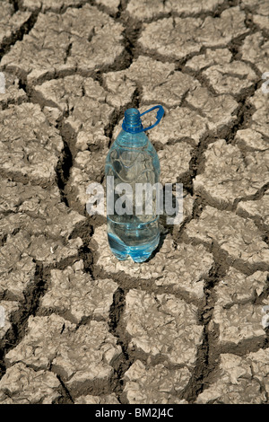 Bottle of potable water on a background of the dried up ground Stock Photo