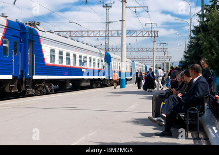 Railway station with passengers and train, Almaty, Kazakhstan Stock Photo