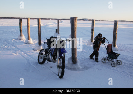 Motorcycles and people on frozen road over the sea in Mariehamn on Aland Islands in the Finland archipelago in deep winter. Photo: Rob Watkins Stock Photo