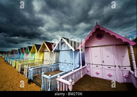 colourful seaside beach huts and shelters at Mersea Island Essex UK Stock Photo