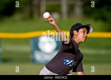 Pitcher in action during boy's little league baseball game. Stock Photo