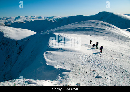 Walkers on the summit of Hopegill Head in winter, Grasmoor Fells, Lake District, Cumbria, England, UK Stock Photo