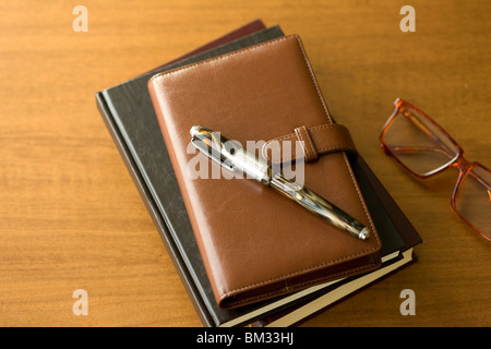 Diary, pen and glasses on a desk Stock Photo