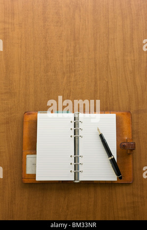 Open diary and ink pen on a desk Stock Photo