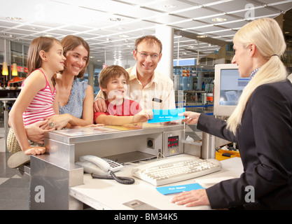 Family checking at the airport desk Stock Photo