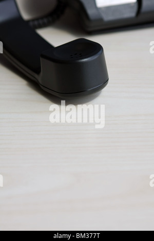 Part of a business telephone with the receiver off the hook Stock Photo