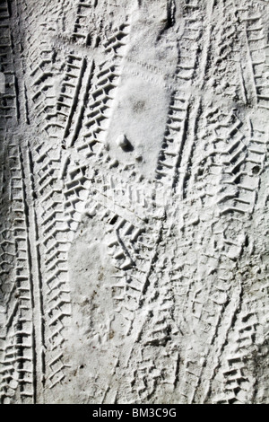 LORRY TIRE TRACKS IN SNOW: Lorry truck van tyre tire prints print tracks winter snow covered frozen road left tyre prints tyre tracks Stock Photo