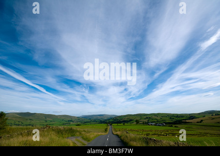 Cirrus cloud over the B6261 road, Crosby Ravensworth Fell near Tebay, Cumbria, England, UK Stock Photo