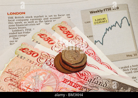 British currency, Sterling pound, on a stock sheet showing the London Stock market FTSE chart. Stock Photo