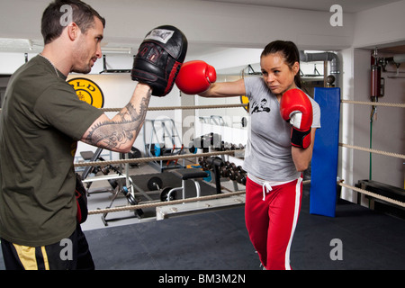 Young woman with coach in boxing ring Stock Photo