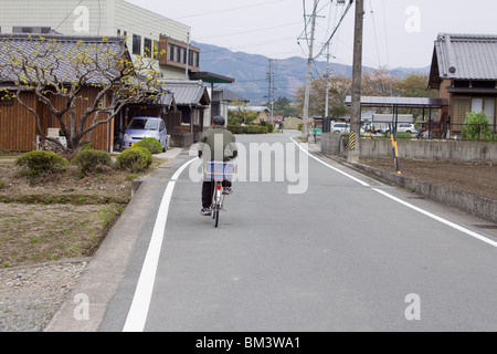 A man riding his bike through the rural Japanese village of Seiwa, Mie Prefecture part of Taki Town, Japan. Stock Photo