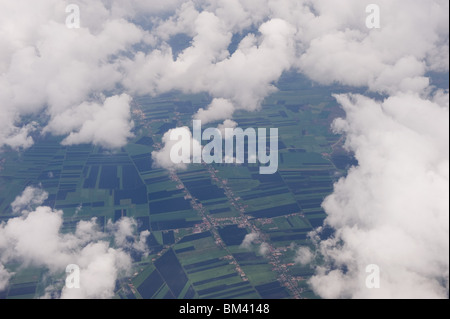 A view from an airplane window showing field patterns through cloud, UK 2010 Stock Photo