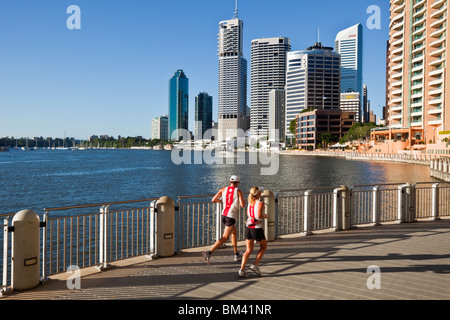 Joggers on the riverside with city skyline in the background. Brisbane, Queensland, Australia Stock Photo