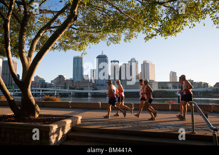 Joggers on the riverside at South Bank with city skyline in the background. Brisbane, Queensland, Australia Stock Photo