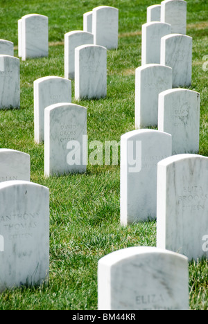 ARLINGTON, Virginia, United States — Rows of white marble headstones stretch across the grounds of Arlington National Cemetery, creating a solemn and visually striking landscape. These uniform gravestones mark the final resting places of American servicemen and women, as well as notable civilians. The meticulously maintained cemetery serves as a powerful tribute to those who have served the United States, offering a place for remembrance and reflection on the sacrifices made for the nation. Stock Photo