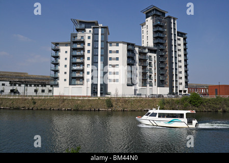 Cardiff Bay Aquabus passing a modern riverside residential block, river Taff Cardiff Wales UK British urban dwellings Modern apertment block Stock Photo