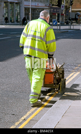 Painting yellow lines on road in London Stock Photo