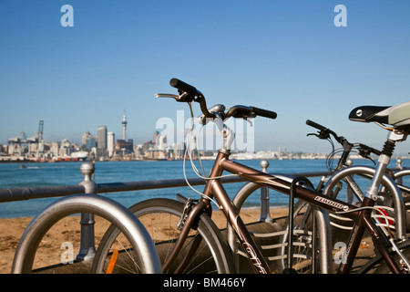 Bicycles on the Devonport waterfront with the city skyline beyond. Devonport, Auckland, North Island, New Zealand Stock Photo