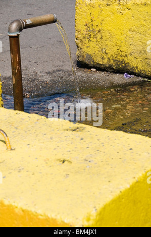 Artesian water free-flowing from the one remaining public well in a parking lot in downtown Olympia, Washington. Stock Photo