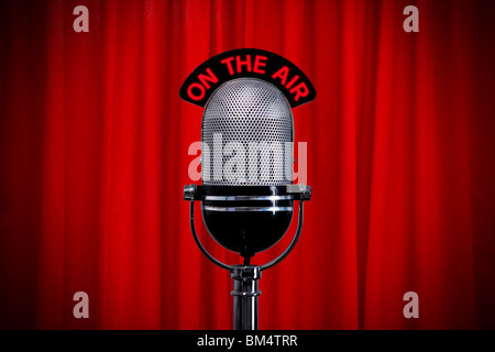 Retro microphone on stage against a red curtain with spotlight effect Stock Photo