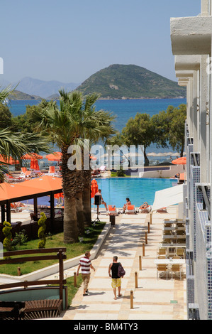 Holidaymakers relax around a hotel swimming pool in the seaside resort of Turgutreis near Bodrum Turkey Stock Photo