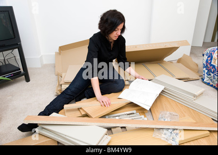 Woman assembling Ikea flat pack furniture, England, UK Stock Photo
